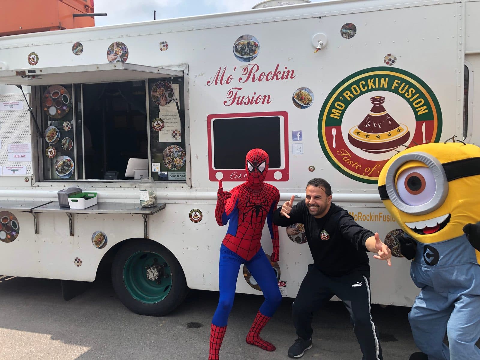 The Mo'Rockin Fusion food truck at an event, with staff and costumed characters in front of the service window